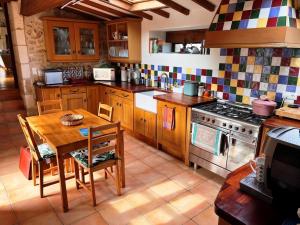 a kitchen with a wooden table and a stove at Fontaine de Champagne in Champagne-et-Fontaine