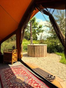 a view from inside of a tent with a rug at Bell Tent in een Voedselbos in Nederweert-Eind