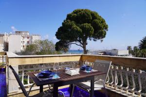 a table and chairs on a balcony with a tree at Sirene Blu Mondello in Palermo