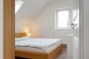 a bedroom with a bed and a window at Symbiola Holiday House in Arnoltice u Decina
