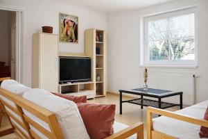 a living room with a couch and a tv at Symbiola Holiday House in Arnoltice u Decina