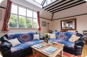 a living room with a blue couch and a table at Spout House Studio in Boldre