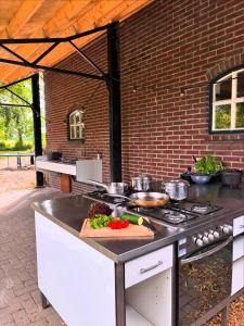 an outdoor kitchen with a counter with pots and pans at Bell Tent in een Voedselbos in Nederweert-Eind