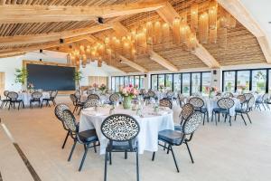 a banquet hall with tables and chairs and chandeliers at Van der Valk Plaza Resort Bonaire - All Inclusive in Kralendijk +102 photos