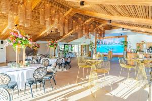 a banquet hall with tables and chairs and chandeliers at Van der Valk Plaza Resort Bonaire - All Inclusive in Kralendijk