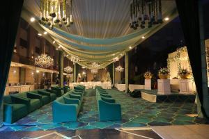 a banquet hall with tables and chairs and chandeliers at Radisson Blu Hotel Rudrapur in Rudrapur +153 photos