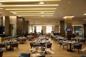 a restaurant with tables and chairs in a room at Radisson Blu Hotel Rudrapur in Rudrapur