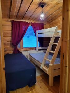 a bedroom with two bunk beds in a log cabin at Huvila Vuosselin Nuppu in Kuusamo