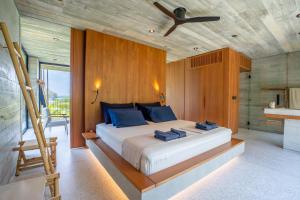 ein Schlafzimmer mit einem großen Bett und einem Deckenventilator in der Unterkunft Cape Pakarang Wow Wild Wellness Escapes in Khao Lak + 69 Fotos