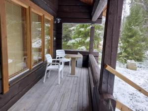 a porch of a cabin with a table and chairs at Huvila Vuosselin Nuppu in Kuusamo +2 photos
