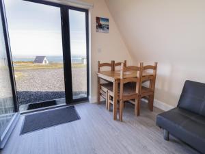 a dining room with a table and a couch at Cabin 9 Inis Beag in Gortahork +13 photos