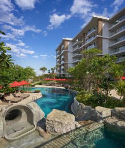 a resort swimming pool with chairs and a building at Amari Pattaya in Pattaya