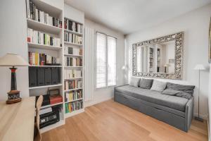 a living room with a couch and book shelves at 100 m terrace parking view of the Eiffel Tower in Saint-Cloud