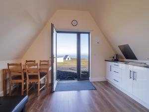 a kitchen and dining room with a view of the ocean at Cabin 8 Inis Dumhaigh in Gortahork