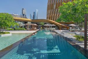 ein Schwimmbad mit einer Brücke in einer Stadt in der Unterkunft Mandarin Oriental Downtown, Dubai in Dubai