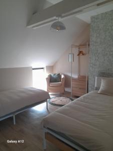 a bedroom with a bed and a chair in it at Maison centre ville Bourgueil in Bourgueil