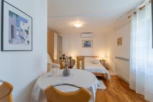 a room with two beds and a table and chairs at Apartments Koraca in Poreč