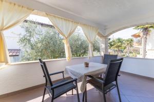 a table and chairs on a balcony with windows at Apartments Koraca in Poreč