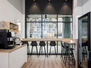 a kitchen with a bar with stools in it at smartments Frankfurt Airport in Frankfurt