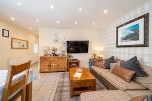 a living room with a couch and a table at Fionas Cottage in Crieff