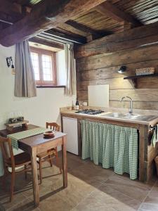 a kitchen with a table and a sink and a stove at Casa Zampani in Massa Martana