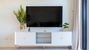 a white entertainment center with a flat screen tv on top at CAMPOROSSO magic apartment in Finestrat +65 photos