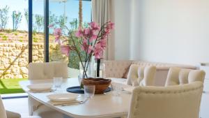 a dining room table with a vase of flowers on it at CAMPOROSSO magic apartment in Finestrat