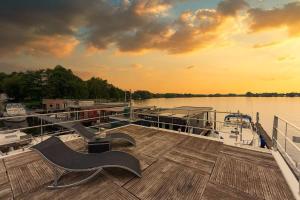 a dock with a bench and a chair on a boat at Floatinghouse Nike in Hennigsdorf