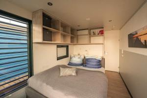 a small bedroom with a bed and a window at Floatinghouse Nike in Hennigsdorf