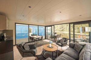 a living room with a couch and chairs and a table at Floatinghouse Nike in Hennigsdorf