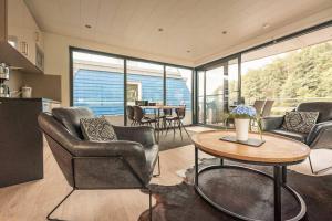 a living room with chairs and a table with a table at Floatinghouse Nike in Hennigsdorf +21 photos