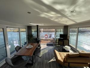 a living room with a table and a couch at Floatinghouse Dicke Bärta in Klitten