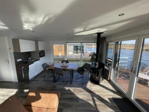 a kitchen and living room with a table and chairs at Floatinghouse Dicke Bärta in Klitten +20 photos