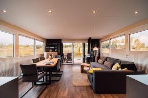 a living room with a couch and a table at Floatinghouse Hideaway LP26 in Klitten