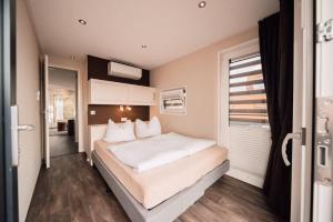 a bedroom with a large bed and a window at Floatinghouse Hideaway LP26 in Klitten