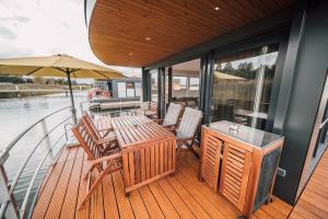 a deck with a table and chairs on a boat at Floatinghouse Hideaway LP26 in Klitten