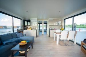 a living room with a blue couch and a kitchen at Floatinghouse Hideaway LP25 in Klitten