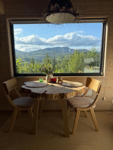a table and chairs in a room with a large window at Miko II in Slavske