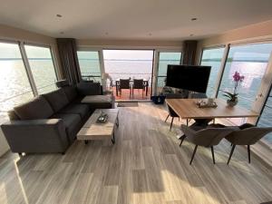 a living room with a couch and a table at Floatinghouse Möwenblick - LP1 in Vetschau