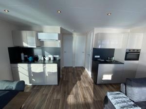 a kitchen with white cabinets and a living room at Floatinghouse Auszeit - LP11 in Vetschau