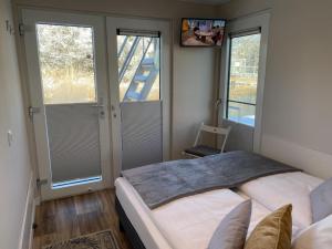 a bedroom with two beds and two windows at Floatinghouse Auszeit - LP11 in Vetschau