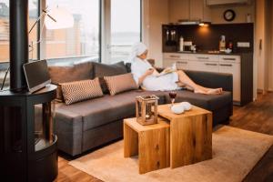 a woman sitting on a couch in a living room at Floatinghouse Seeschwäche - LP12 in Vetschau