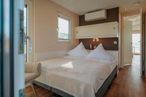 a bedroom with a large bed and a chair at Floatinghouse Seelenbaumler - LP13 in Vetschau