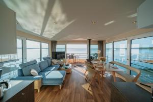 a living room with a blue couch and a table at Floatinghouse Seelenbaumler - LP13 in Vetschau