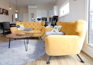 a living room with a yellow couch and a table at Floatinghouse Bernstein Suite in Ribnitz-Damgarten