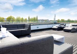 a rooftop patio with couches and tables on a roof at Floatinghouse Bernstein Suite in Ribnitz-Damgarten