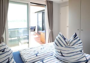 a bedroom with a bed with blue and white pillows at Floatinghouse Ankerplatz in Ribnitz-Damgarten