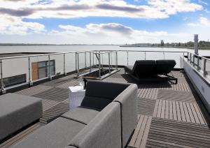 a deck with two couches and chairs on a boat at Floatinghouse Ankerplatz in Ribnitz-Damgarten