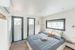 a bedroom with a bed and a window at Floatinghouse Achat in Zehdenick