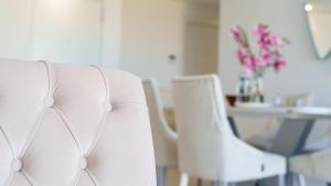 two white chairs sitting next to a table with flowers at CAMPOROSSO magic apartment in Finestrat